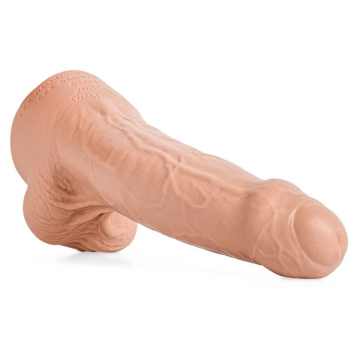 Silicone adult novelty toy shaped like a realistic phallic form, skin-tone color, detailed texture, shown lying at an angle.