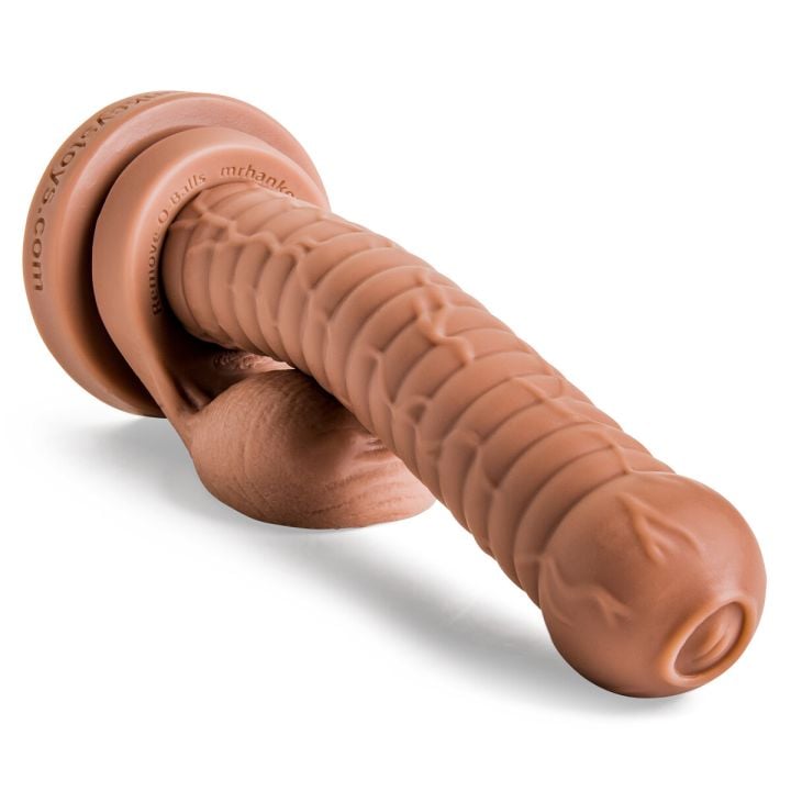 Cyclops fantasy dildo laying flat, close-up view of sculpted head and textured veins with attached Remove-O-Balls in Natural Tan silicone.