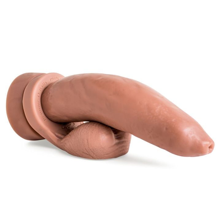 Ramrodder silicone dildo laying flat in Natural Tan with Remove-O-Balls attached, showcasing realistic uncut head and handcrafted texture.