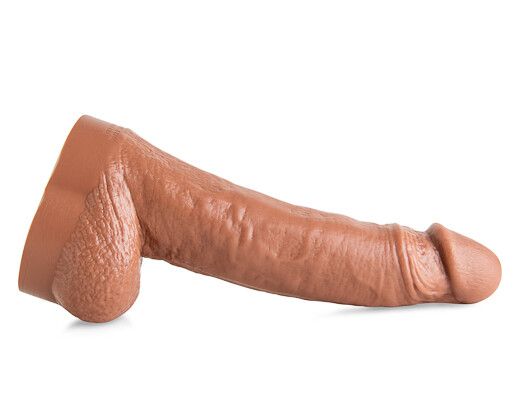 Side view of the Dominic Pacifico silicone dildo in Natural Tan, featuring sculpted uncut head and thick shaft for lifelike power play and deep penetration.