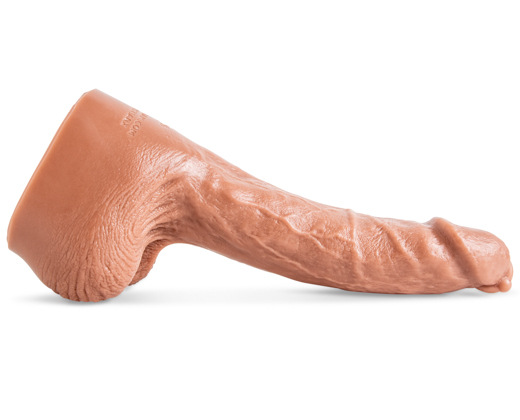 Drew Sebastian dildo by Mr. Hankey’s Toys laying flat, side view showing curved shaft, textured veins, and lifelike sculpt in Natural Tan silicone.